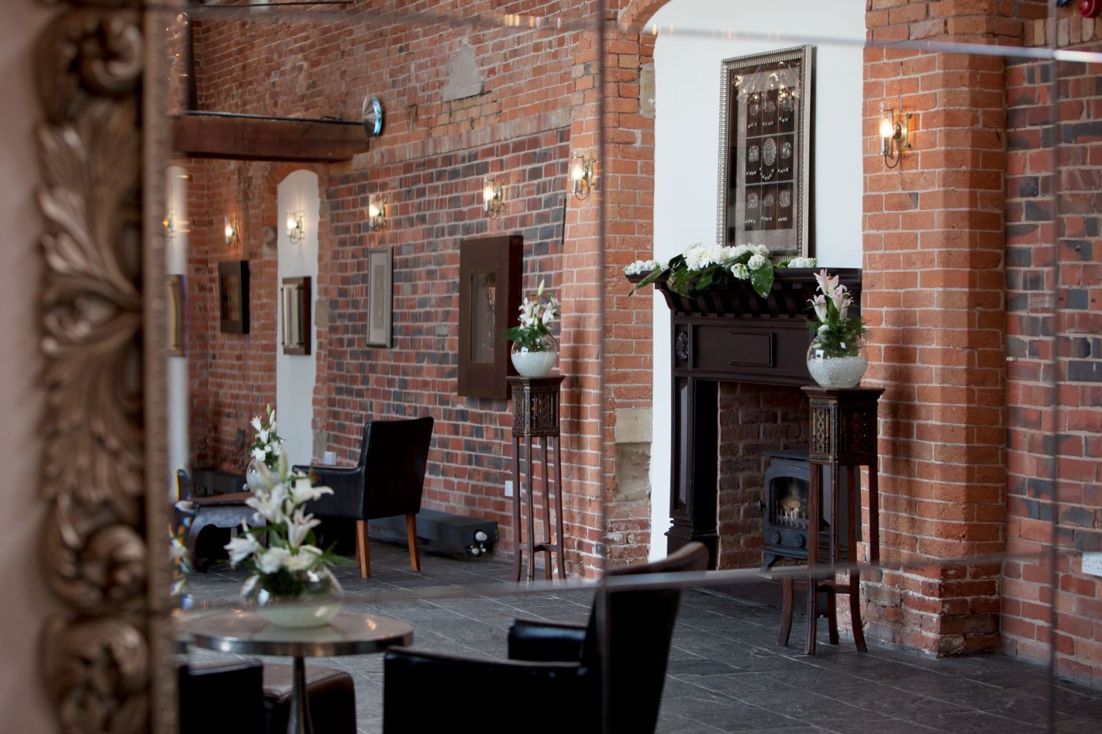 Brick interior with fireplace and chairs