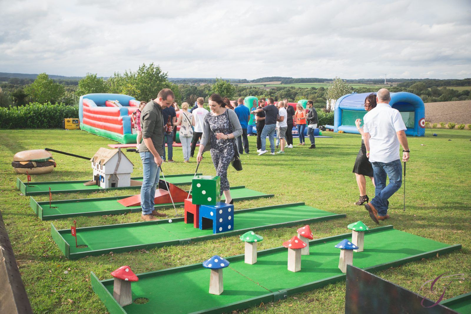 People playing mini golf at an outdoor fairground