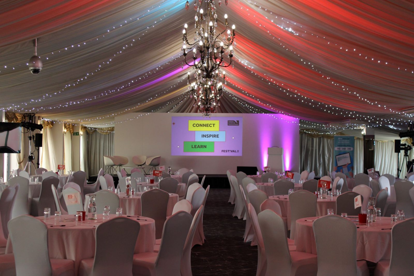 Corporate event setup with tables and projected screens