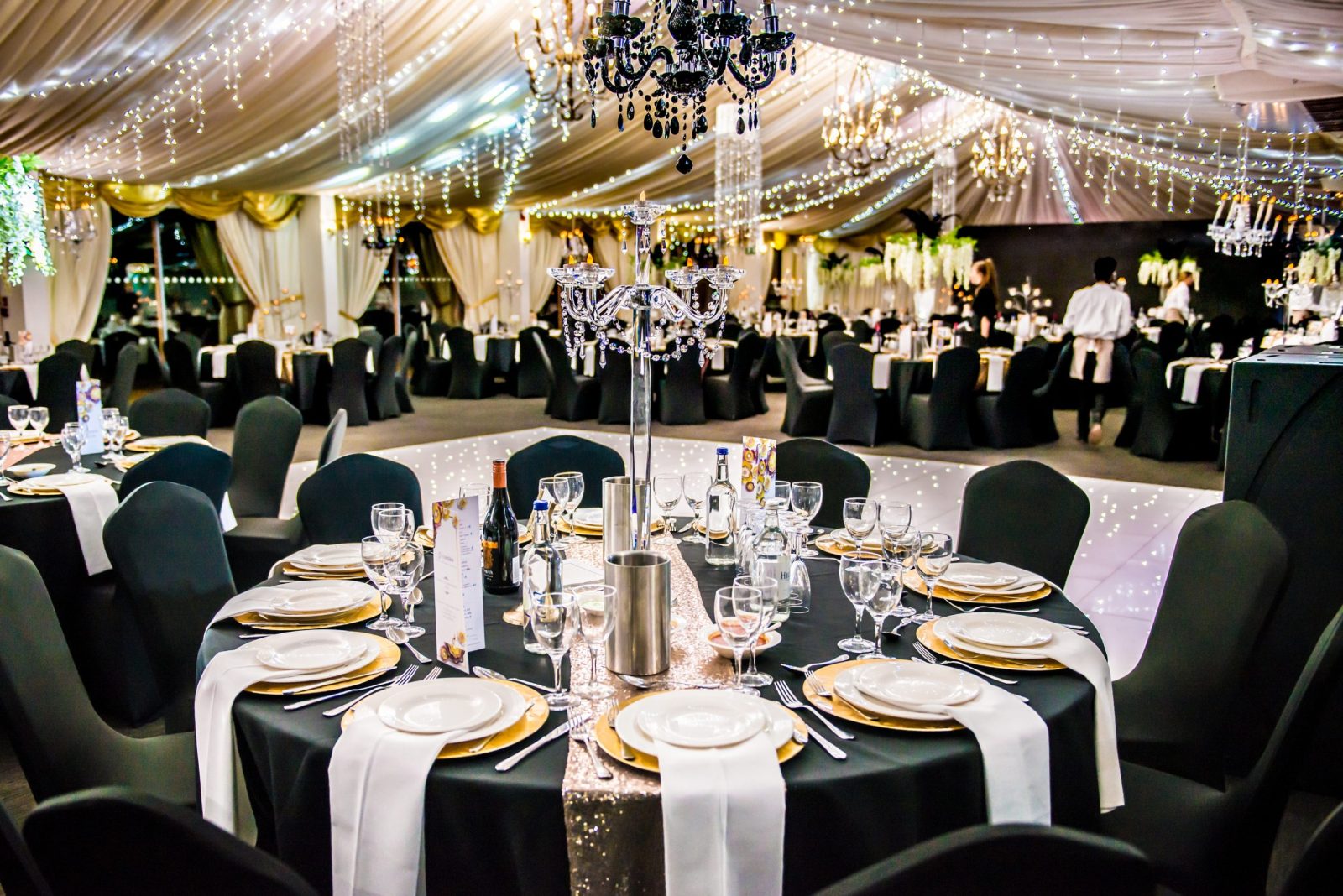 Elegant banquet setup with chandeliers and decorated tables