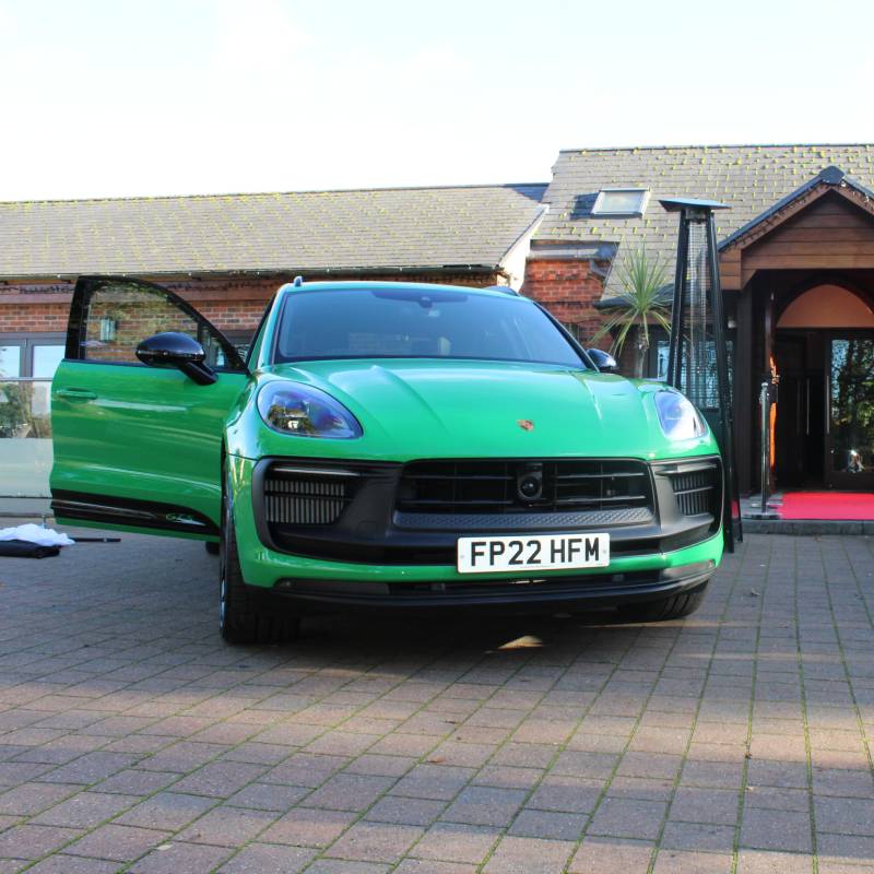 Green Porsche parked at the entrance of the venue